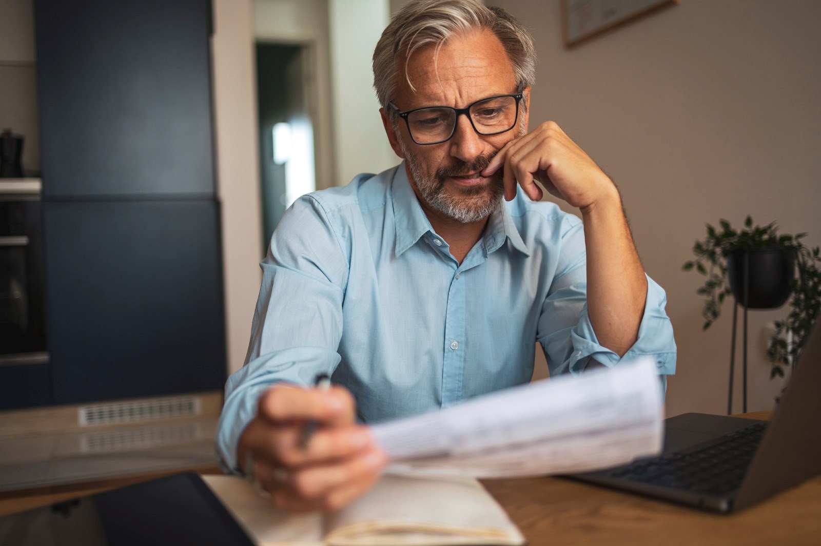 Man sitting at a table looking at documents concerned