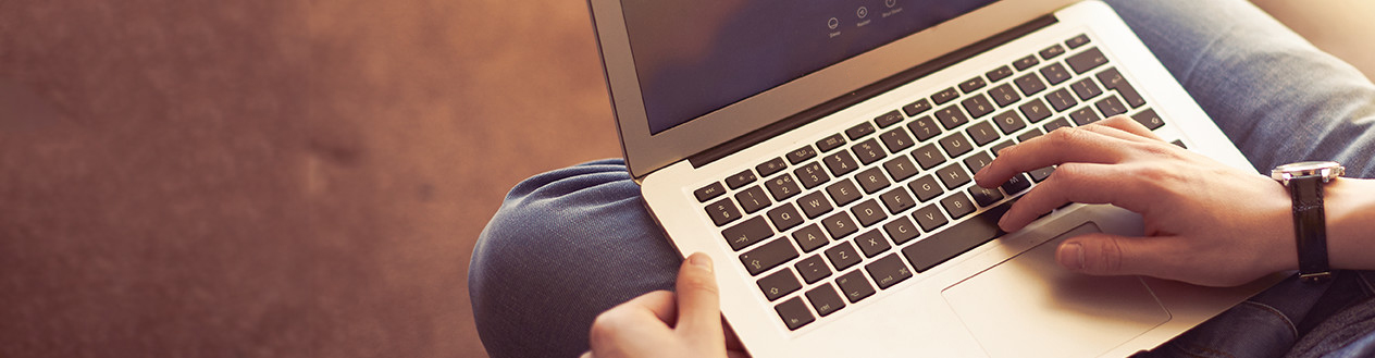 A close up of a laptop on a mans lap 