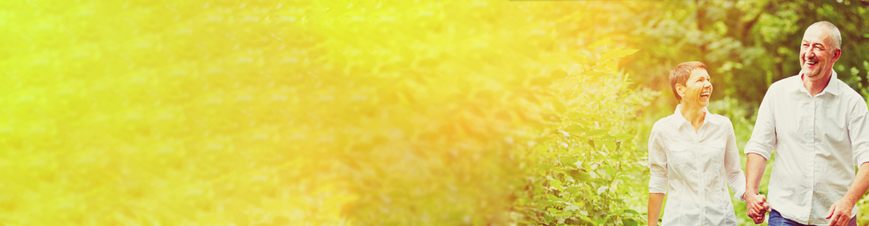 Older couple smiling and walking outside in a garden on a summers day