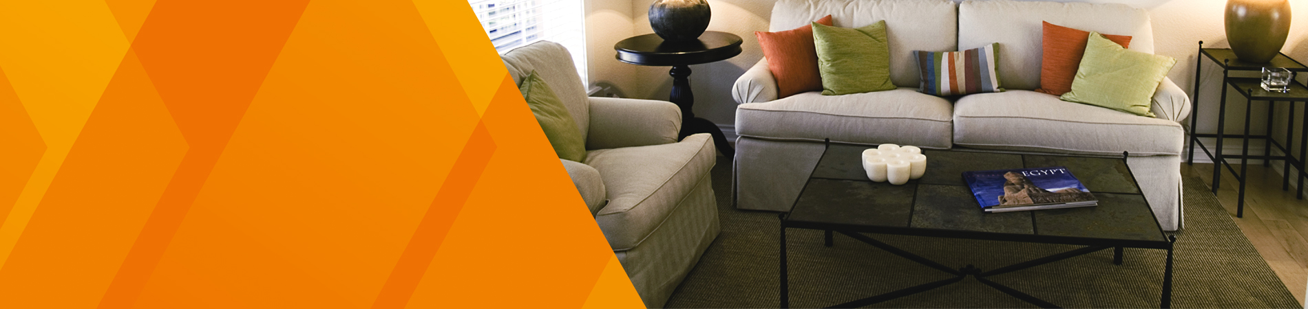 A living room with a coffee table, rug and sofas