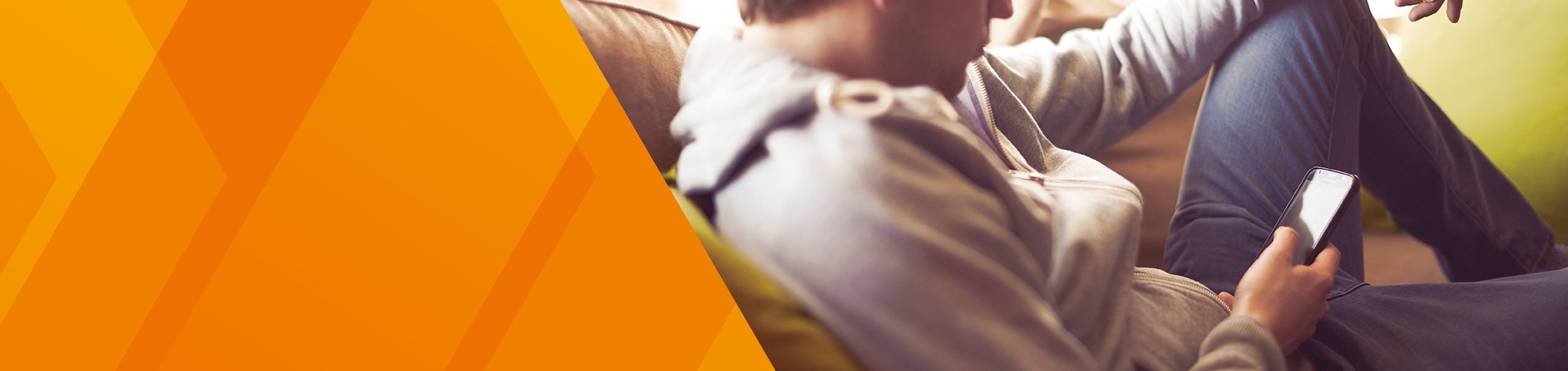 Man sitting comfortably on a sofa looking at his mobile