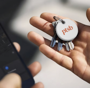 Chipolo pop tag attached to set of keys  placed on a hand